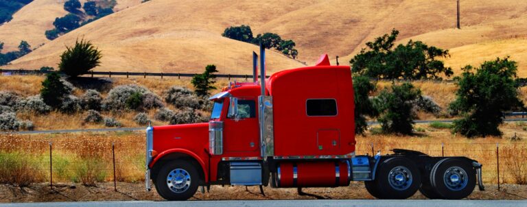 Red semi truck bobtail driving in California