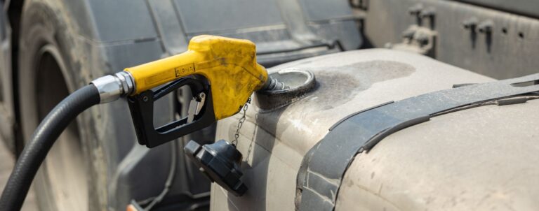 A truck's fuel tank getting fueled.
