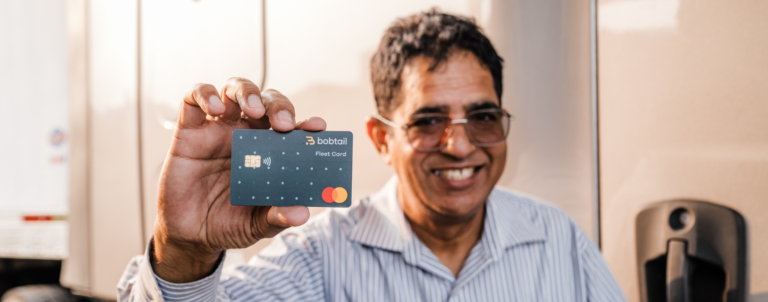 Truck driver holding up a Bobtail fleet card